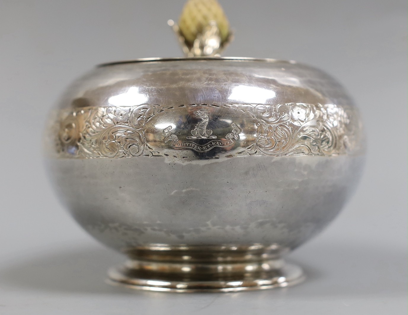 A George V engraved silver globular tea caddy, with carved stained wooden pineapple shaped knop, Goldsmiths & Silversmiths Co Ltd, London, 1920, height 11.3cm, gross weight 12oz.